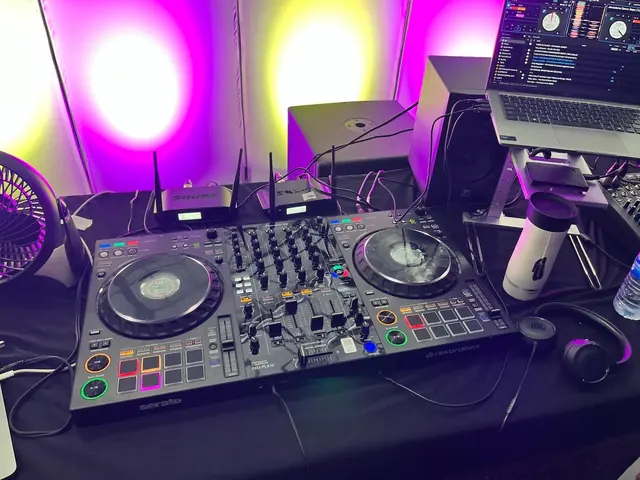 Rubicon's Pioneer DJ controller, wireless microphone receivers and monitors under purple and gold uplighting