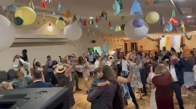 Guests dancing under paper lanterns and bunting at a celebration
