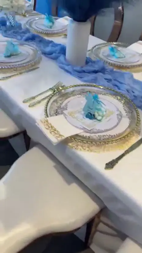 Video: A baby shower table set in blue and gold, with balloons behind