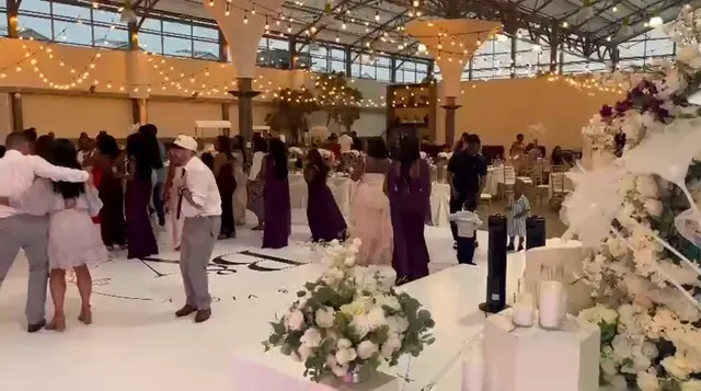 Guests dancing on a white dance floor at a wedding reception